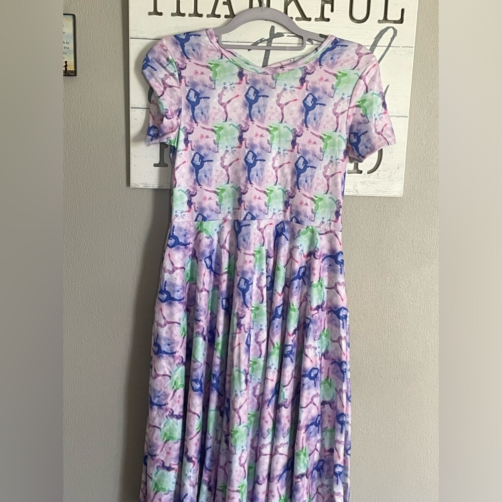 Girls dress lavender back with gymnastics figures.